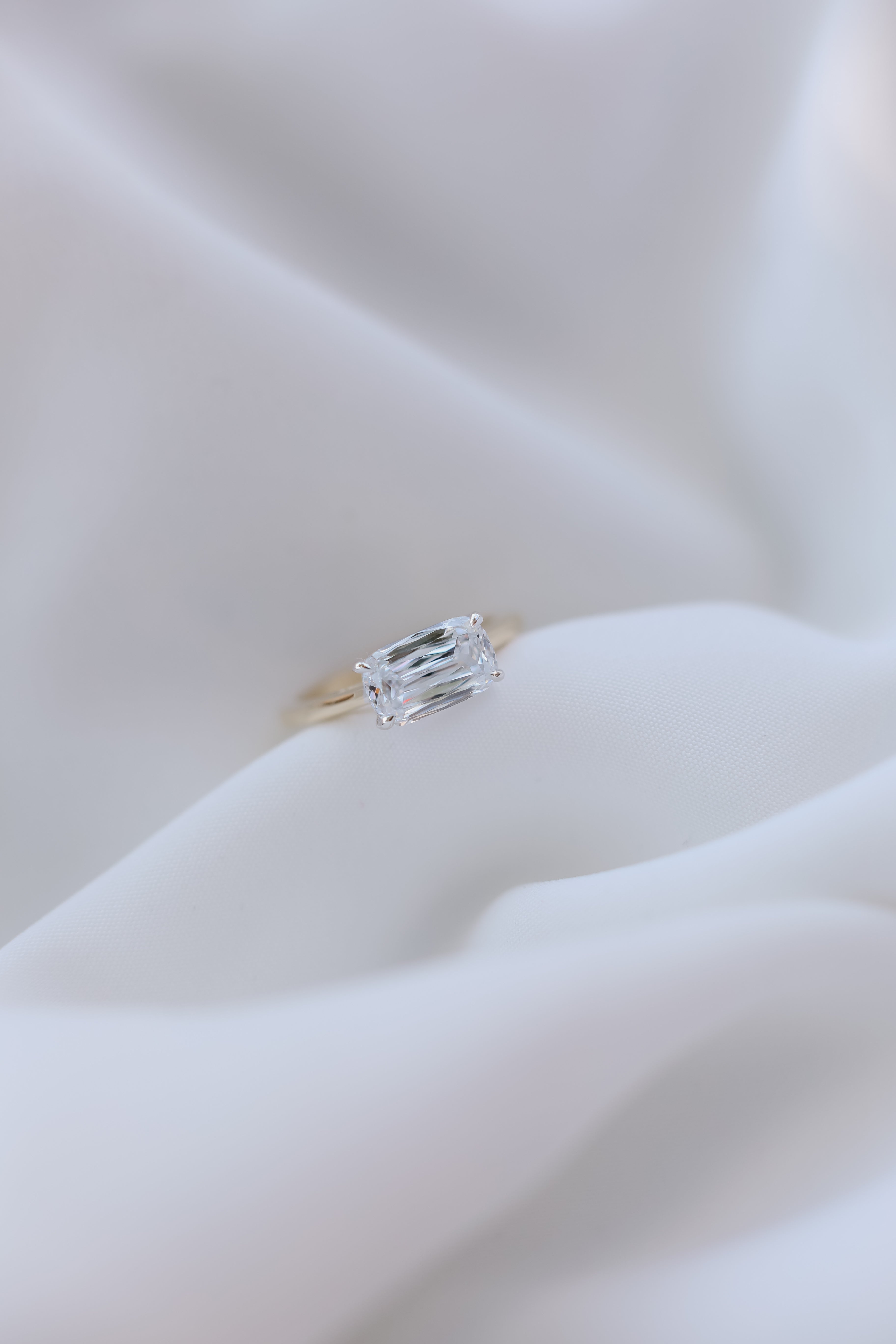 1.90 crisscut cushion E VS1 on an east west setting in 14k yellow gold with white gold prongs