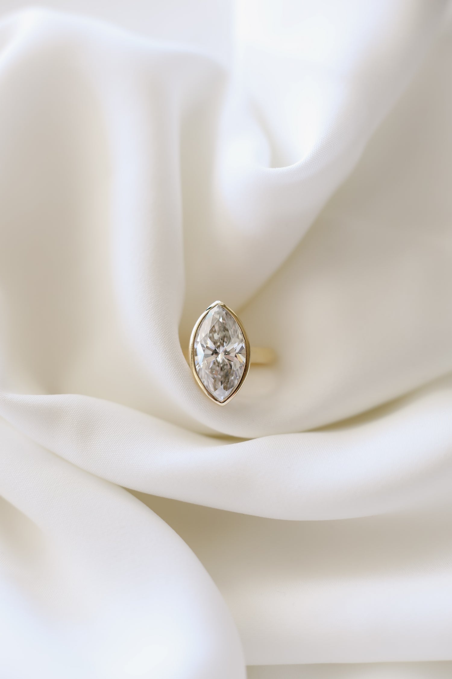 Marquise diamond ring with a bzel setting on a 3mm 14k yellow gold band. 6.06ct, E color, VVS2 clarity